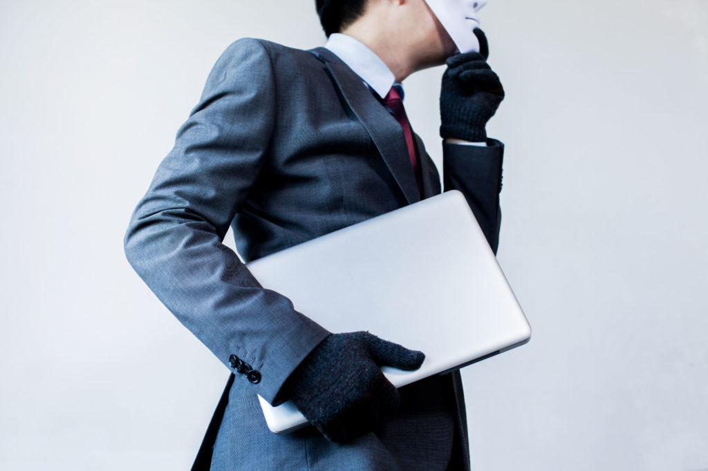 Business man holding laptop while wearing white mask